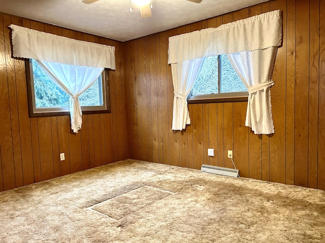 6870 N Spruce Rd, Spruce, MI 48762 - carpeted spare room with baseboard heating, a ceiling fan, wooden walls, and a textured ceiling