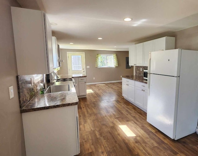 6131 N F41, Spruce, MI 48762 - kitchen with freestanding refrigerator, white cabinets, dark wood-style flooring, dark countertops, and a sink