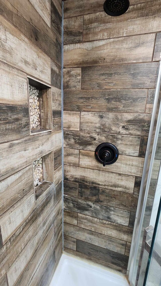 6131 N F41, Spruce, MI 48762 - bathroom with tiled shower and wood walls