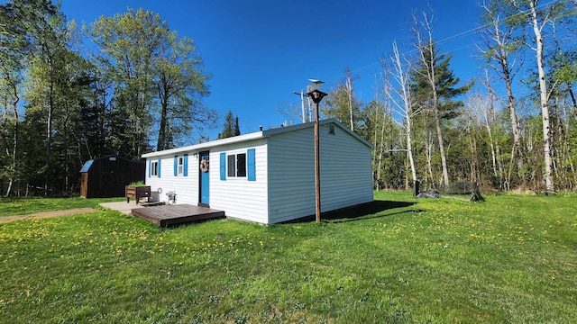 6131 N F41, Spruce, MI 48762 - back of property featuring an outdoor structure, a yard, and a deck