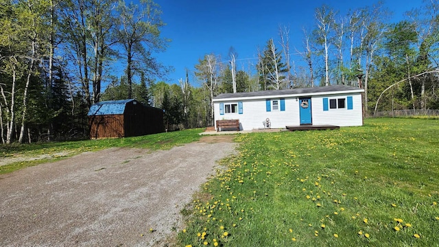 6131 N F41, Spruce, MI 48762 - view of front of property featuring an outdoor structure and a front yard