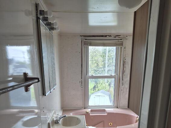 full bathroom with a sink and a jetted tub