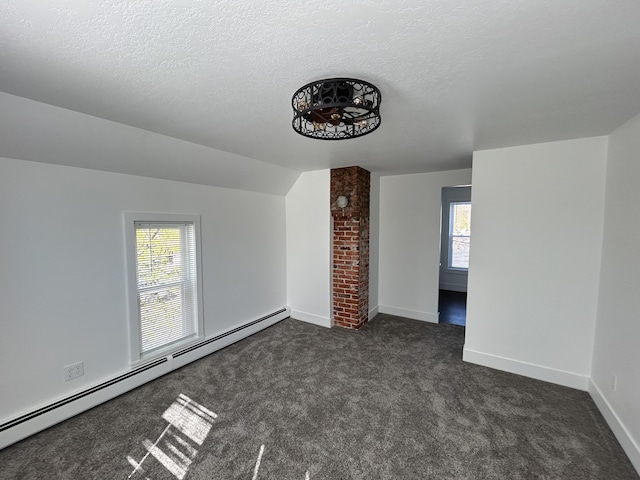 1033 S First Ave, Alpena, MI 49707 - unfurnished living room featuring a baseboard radiator, healthy amount of natural light, dark carpet, baseboards, and vaulted ceiling
