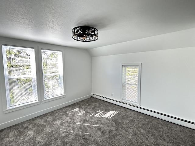 1033 S First Ave, Alpena, MI 49707 - carpeted spare room with plenty of natural light, baseboard heating, baseboards, lofted ceiling, and a textured ceiling