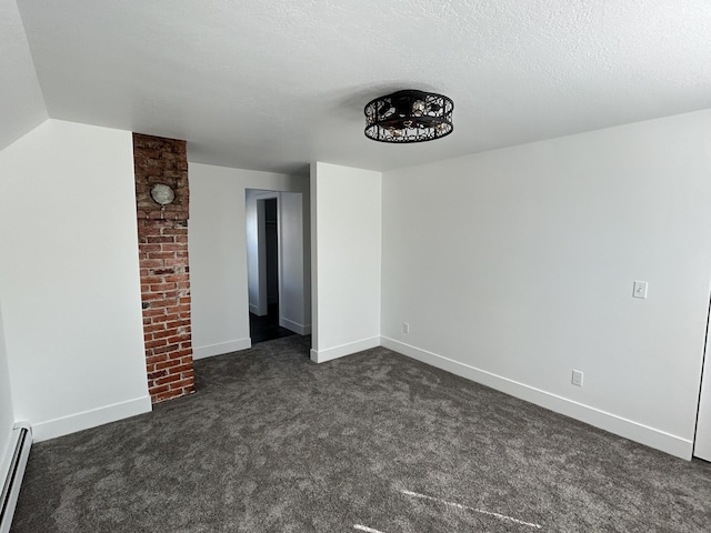 1033 S First Ave, Alpena, MI 49707 - spare room featuring dark colored carpet, a baseboard radiator, baseboards, and a textured ceiling