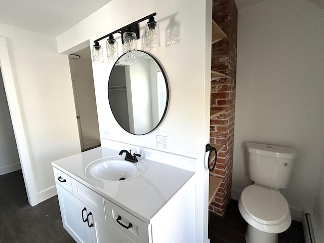 1033 S First Ave, Alpena, MI 49707 - bathroom featuring vanity, toilet, wood finished floors, and baseboards