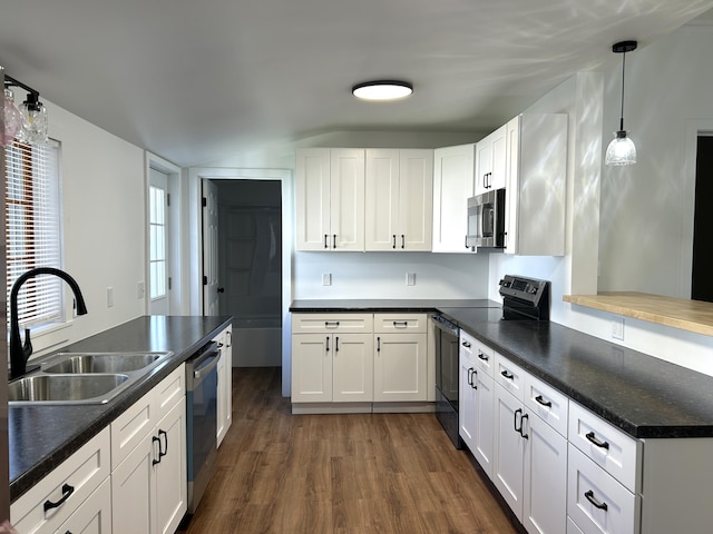 1033 S First Ave, Alpena, MI 49707 - kitchen featuring stainless steel appliances, a sink, dark wood-type flooring, white cabinets, and dark countertops