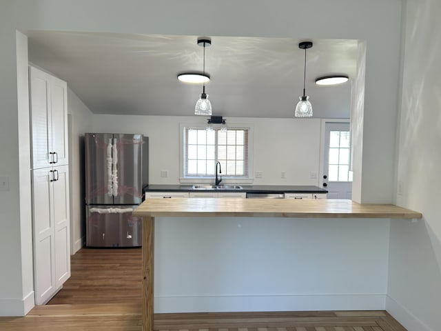 1033 S First Ave, Alpena, MI 49707 - kitchen featuring stainless steel appliances, wooden counters, a sink, a peninsula, and baseboards