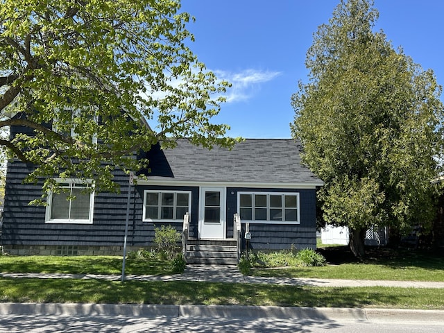 1033 S First Ave, Alpena, MI 49707 - view of front of property featuring entry steps, a front yard, and a shingled roof