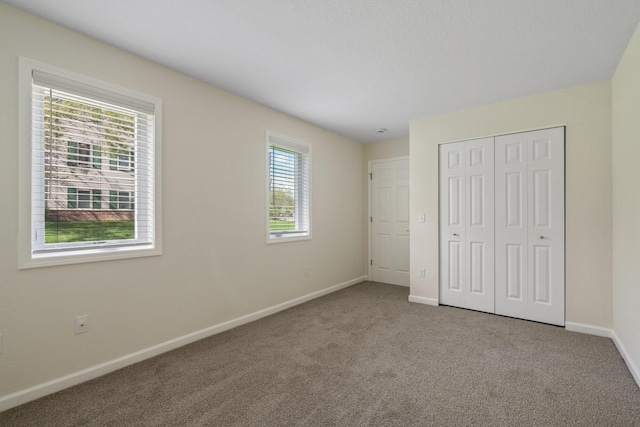 2067 Woods Ln, Petoskey, MI 49770 - unfurnished bedroom with baseboards, carpet, and a closet