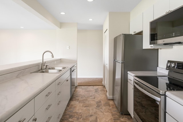 2067 Woods Ln, Petoskey, MI 49770 - kitchen with stainless steel appliances, a sink, stone finish floors, light countertops, and recessed lighting