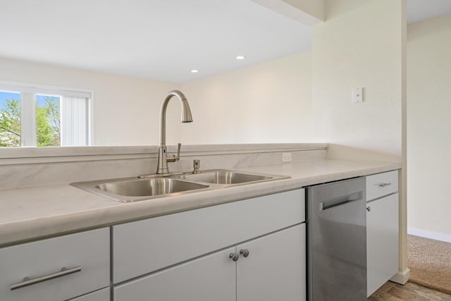 2067 Woods Ln, Petoskey, MI 49770 - kitchen with stainless steel dishwasher, a sink, light countertops, white cabinetry, and recessed lighting