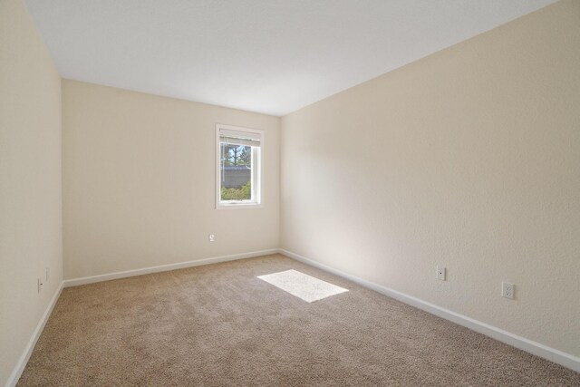 2067 Woods Ln, Petoskey, MI 49770 - spare room featuring carpet flooring and baseboards