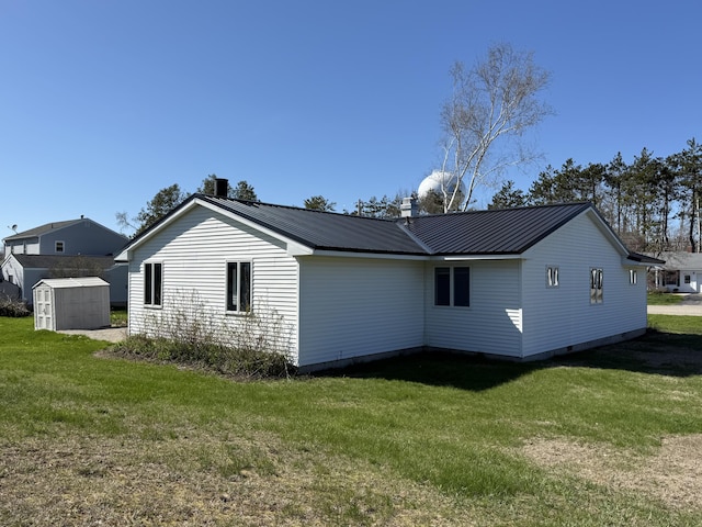 638 Snow Apple Ct, Cheboygan, MI 49721 - view of home's exterior featuring a chimney, a lawn, and metal roof