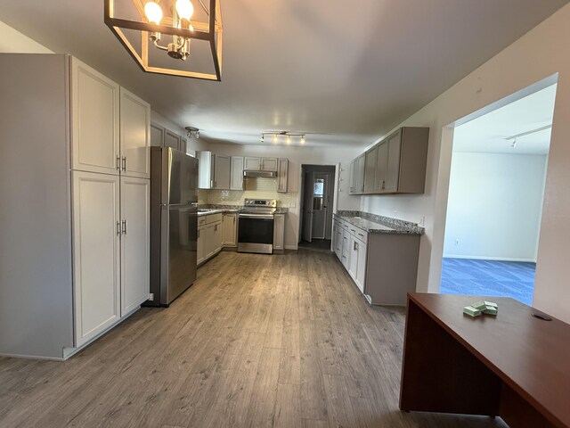 638 Snow Apple Ct, Cheboygan, MI 49721 - kitchen with stainless steel appliances, track lighting, light wood-style floors, under cabinet range hood, and gray cabinets