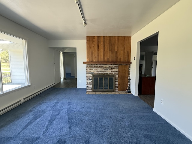 638 Snow Apple Ct, Cheboygan, MI 49721 - unfurnished living room featuring dark carpet, rail lighting, a fireplace, and baseboards