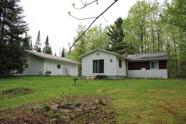 1421 W Miller Rd, Mio, MI 48647 - back of house featuring a yard, a chimney, and entry steps