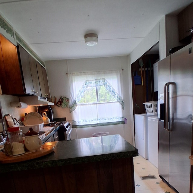 1421 W Miller Rd, Mio, MI 48647 - kitchen with stainless steel appliances, a peninsula, dark countertops, independent washer and dryer, and under cabinet range hood