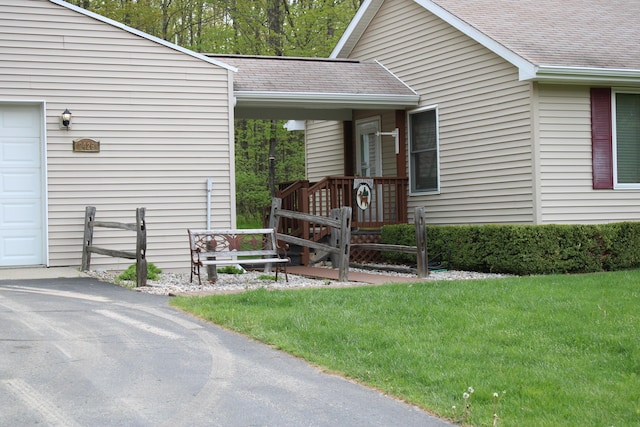 2426 W Park Rd, Mio, MI 48647 - doorway to property featuring roof with shingles, a yard, and driveway