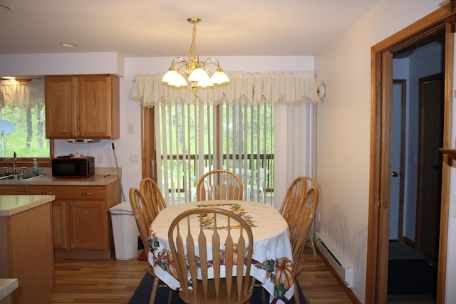 2426 W Park Rd, Mio, MI 48647 - dining space with wood finished floors, a chandelier, and baseboard heating