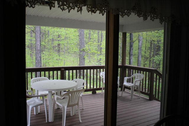 2426 W Park Rd, Mio, MI 48647 - wooden terrace with outdoor dining area and a view of trees