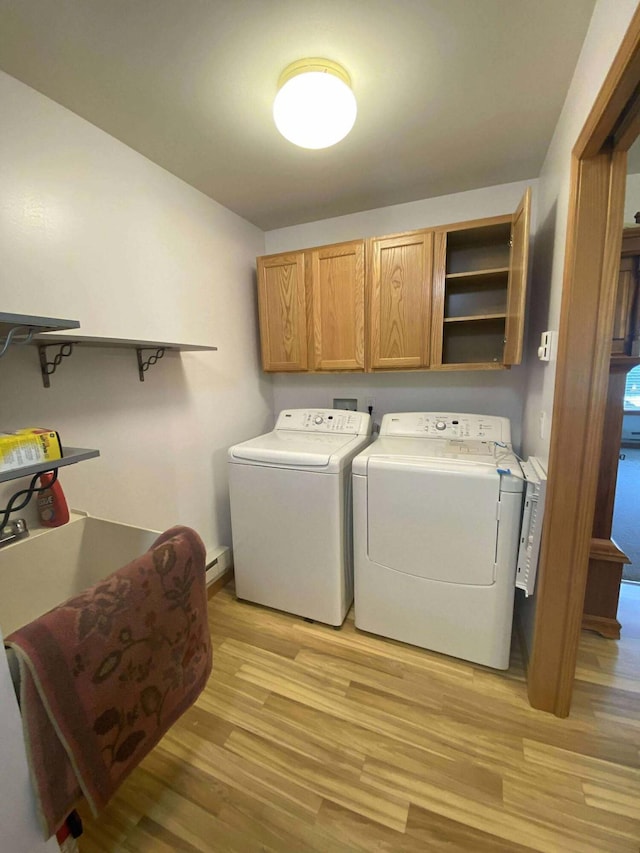 2426 W Park Rd, Mio, MI 48647 - washroom featuring washing machine and clothes dryer, cabinet space, and light wood-style flooring