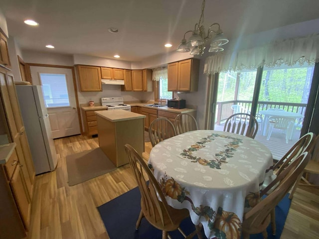 2426 W Park Rd, Mio, MI 48647 - kitchen featuring white appliances, a center island, light countertops, a chandelier, and a sink