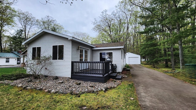 610 Old Trail Dr, Houghton Lake, MI 48629 - view of front of home with an outdoor structure, a wooden deck, and a garage