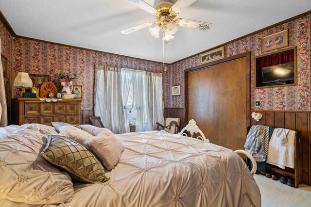 6620 N Straits Hwy, Cheboygan, MI 49721 - bedroom featuring wallpapered walls, wainscoting, carpet floors, crown molding, and a closet