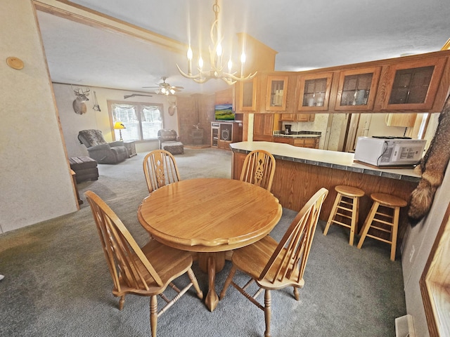 5844 Keipinger Trl, Grayling, MI 49738 - dining room featuring carpet flooring, a chandelier, and a ceiling fan