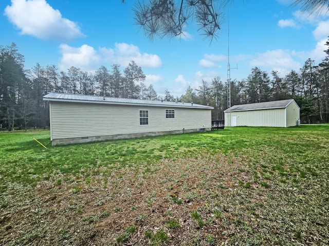 5844 Keipinger Trl, Grayling, MI 49738 - rear view of house featuring a lawn, metal roof, crawl space, and an outbuilding