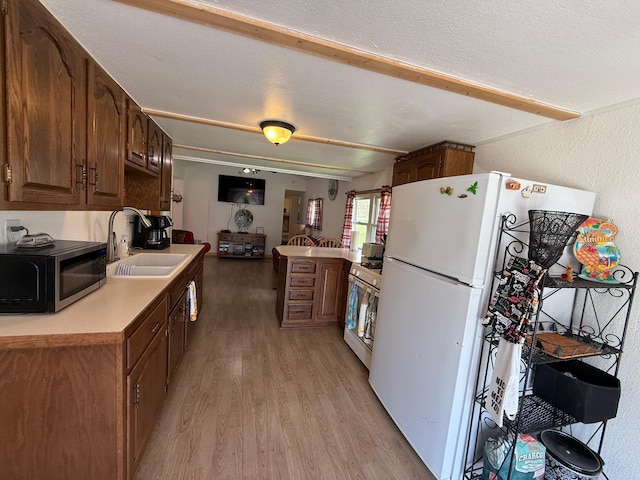 10117 M-18, Gladwin, MI 48624 - kitchen with a sink, white appliances, light wood-style floors, light countertops, and a textured ceiling