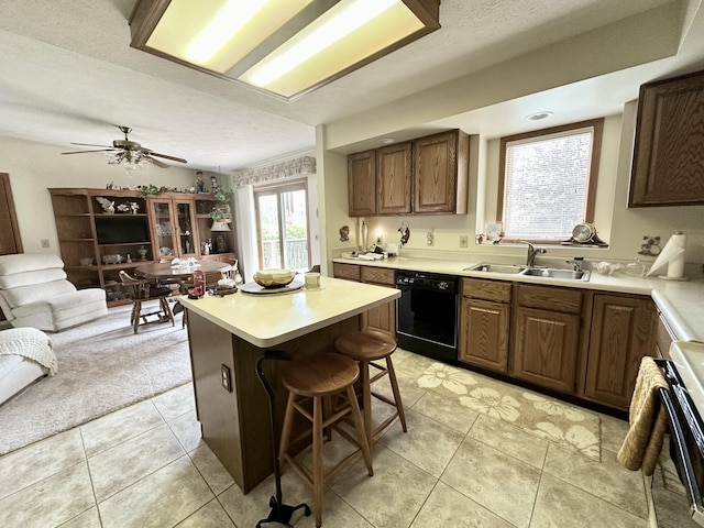 173 N Addison St, Alpena, MI 49707 - kitchen with black dishwasher, a sink, open floor plan, a kitchen island, and light countertops