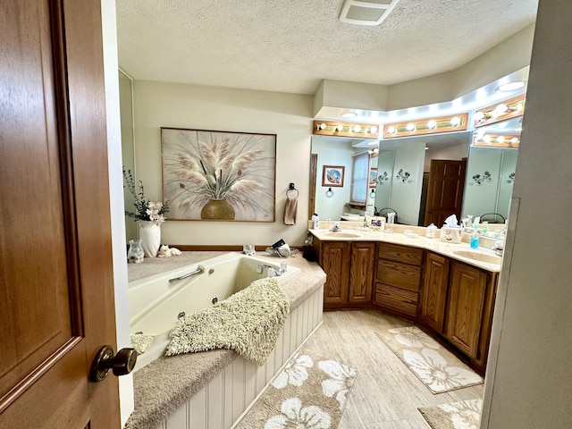 173 N Addison St, Alpena, MI 49707 - full bathroom with a jetted tub, double vanity, and a textured ceiling
