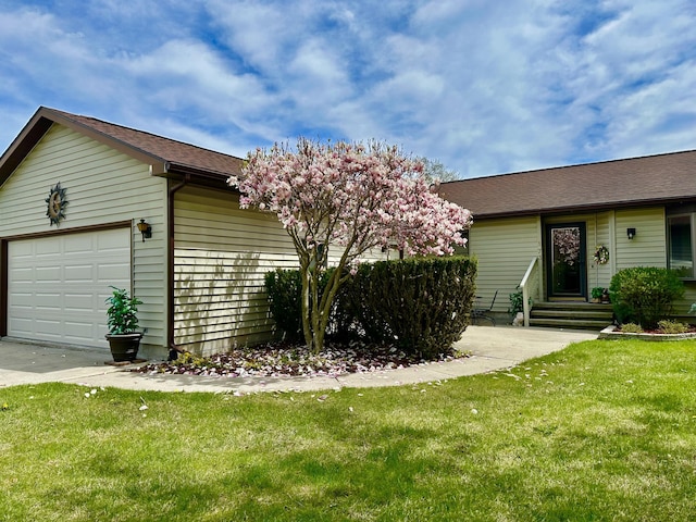 173 N Addison St, Alpena, MI 49707 - view of front of house featuring an attached garage, a front yard, and concrete driveway
