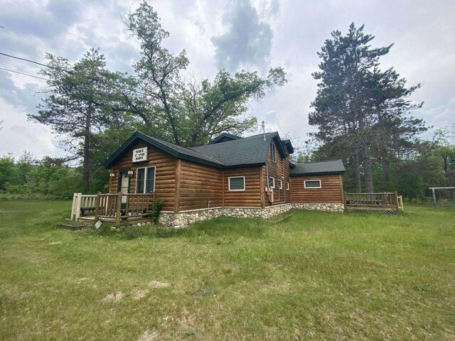 5626 Smith Rd, Lewiston, MI 49756 - view of side of home featuring a lawn, a deck, faux log siding, and roof with shingles