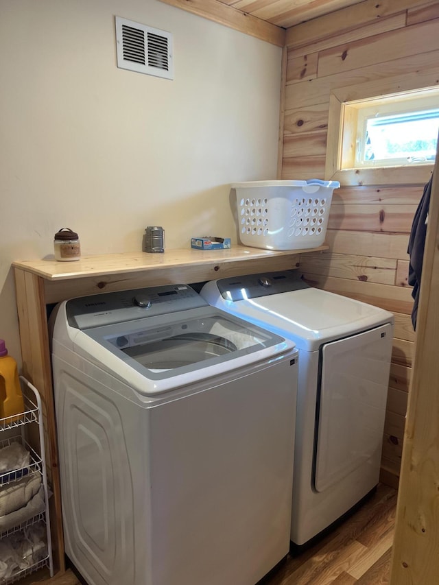 468 Pine Oak Trl, Grayling, MI 49738 - laundry room featuring washing machine and dryer, wooden walls, and wood finished floors