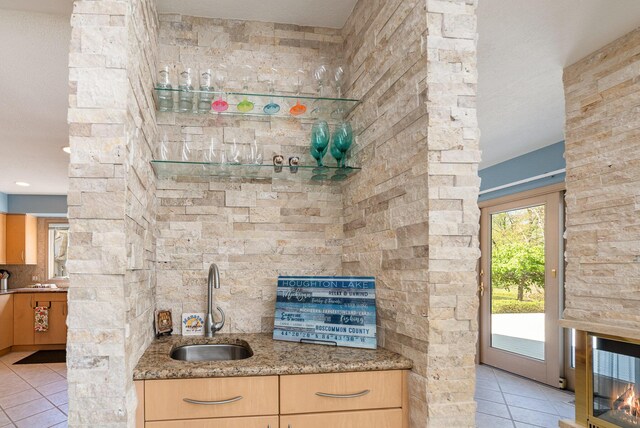 118 Harbor Ct, Houghton Lake, MI 48629 - kitchen featuring light tile patterned floors, a sink, light stone counters, and light brown cabinetry
