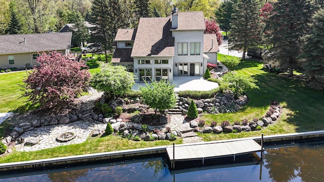 118 Harbor Ct, Houghton Lake, MI 48629 - rear view of house with a patio area, a yard, a chimney, and a shingled roof
