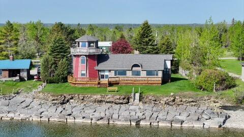 2215 N Partridge Point Rd, Alpena, MI 49707 - rear view of property with a water view, a lawn, and a view of trees