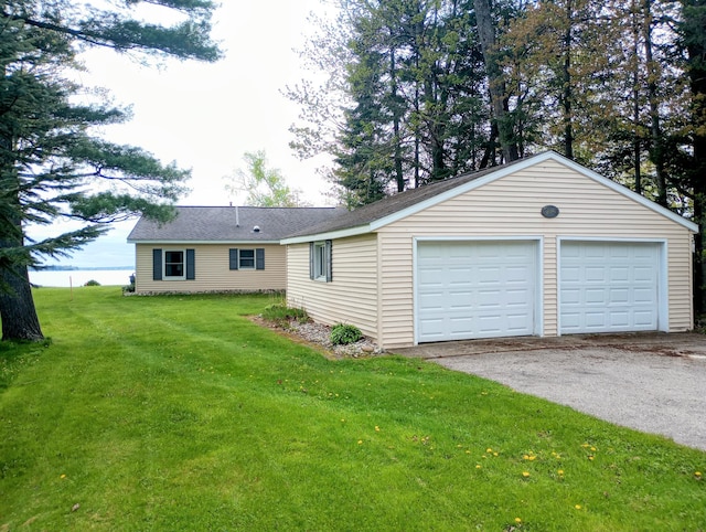 12243 E Houghton Lake Dr, Houghton Lake, MI 48629 - view of front facade with an outbuilding, a front yard, and a garage