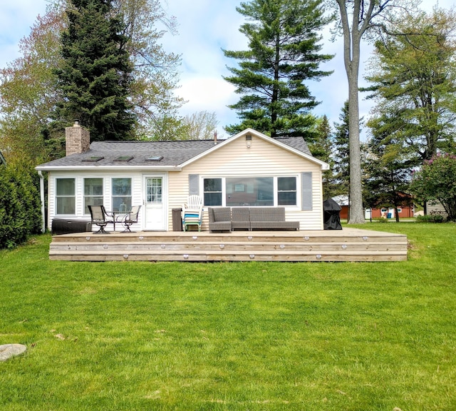 12243 E Houghton Lake Dr, Houghton Lake, MI 48629 - back of house featuring a deck, a chimney, and a lawn