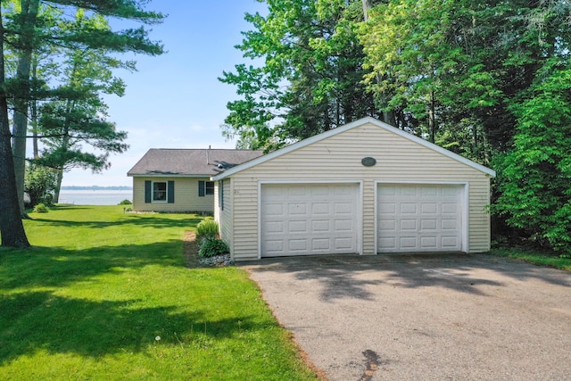 12243 E Houghton Lake Dr, Houghton Lake, MI 48629 - view of front of home featuring a garage, a front lawn, and an outbuilding