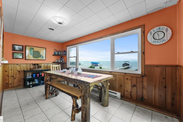 12243 E Houghton Lake Dr, Houghton Lake, MI 48629 - dining space with wainscoting, wood walls, a water view, and light tile patterned floors