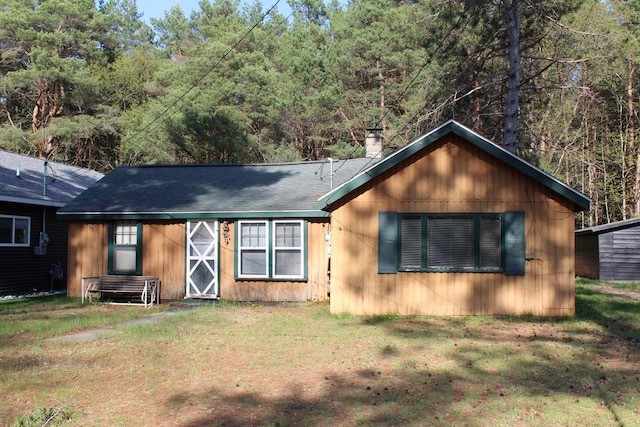 110 Mulberry Ln, Roscommon, MI 48653 - view of front of property with a chimney, a front lawn, and roof with shingles