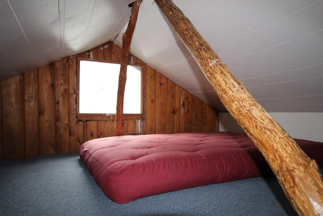 110 Mulberry Ln, Roscommon, MI 48653 - bedroom with wooden walls, vaulted ceiling, and carpet flooring