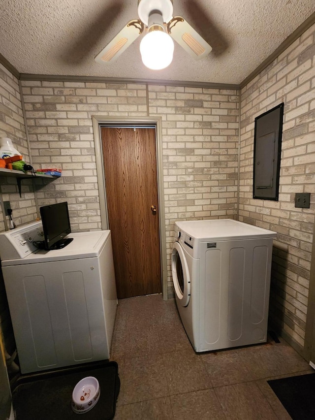 8881 Artesia Beach Rd, Saint Helen, MI 48656 - laundry area featuring washer and dryer, electric panel, a textured ceiling, brick wall, and a ceiling fan