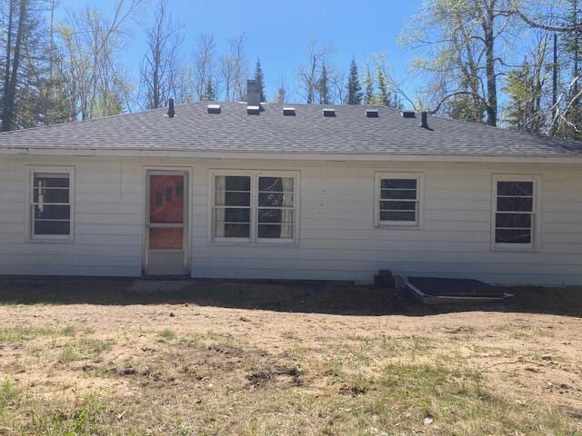 19204 Marlin Ln, Ocqueoc, MI 49759 - rear view of property with a shingled roof, a lawn, and a chimney