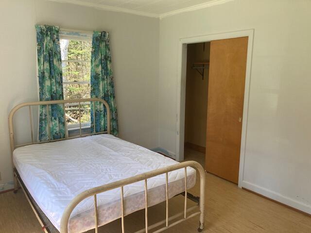 19204 Marlin Ln, Ocqueoc, MI 49759 - bedroom with crown molding, wood finished floors, baseboards, and a closet