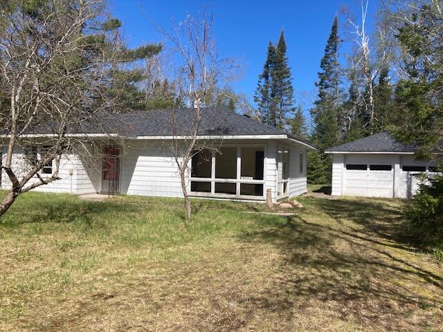 19204 Marlin Ln, Ocqueoc, MI 49759 - rear view of property featuring a detached garage and a lawn